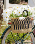 A Bolga basket filled with white flowers on a Bluejay e-bike in Olive Green.