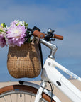 Handlebars of Bluejay Lite e-bike with basket full of flowers
