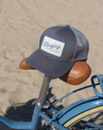 Bluejay e-bike trucker hat sits on seat of e-bike