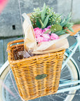 A bouquet of flowers in a Pannier Nantucket basket on a Bluejay e-bike in Mint Green
