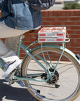 Person riding Bluejay Lite e-bike with pizza boxes on the rear rack.