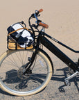 Black Bluejay Premiere Lite e-bike on beach with lock and towel in front rack