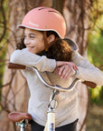 Kid wearing Thousand Jr. bike helmet in Pink