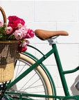 Bluejay Premiere Edition e-bike in British Racing Green with rear basket of flowers