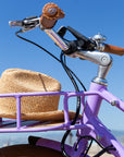 Bluejay Premiere Edition e-bike in French Lavender with straw hat in front rack 