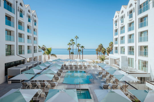 View of hotel pool near beach with palm trees 