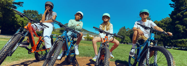 Kids sitting on Bluejay WILD kids' e-bikes 