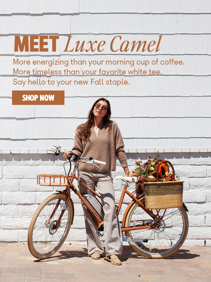 Woman standing with Bluejay Premiere Edition e-bike in Luxe Camel 