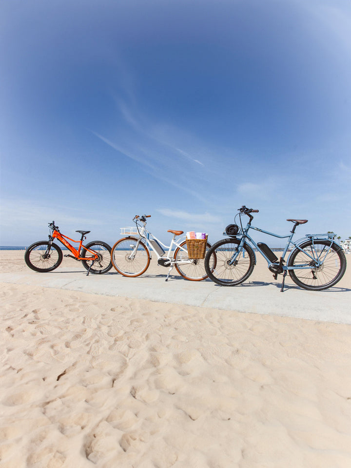 Bluejay bicycles sitting at the beach on a sunny day. 