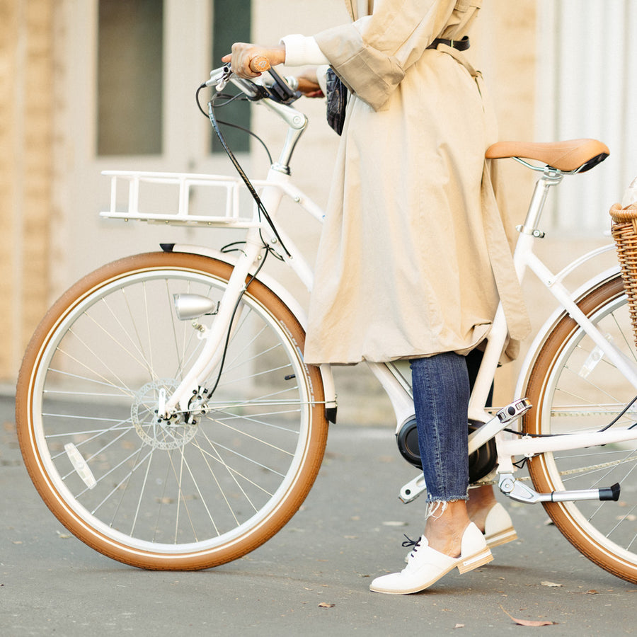 Woman with the Premiere Edition Modern White Electric Bike by Bluejay